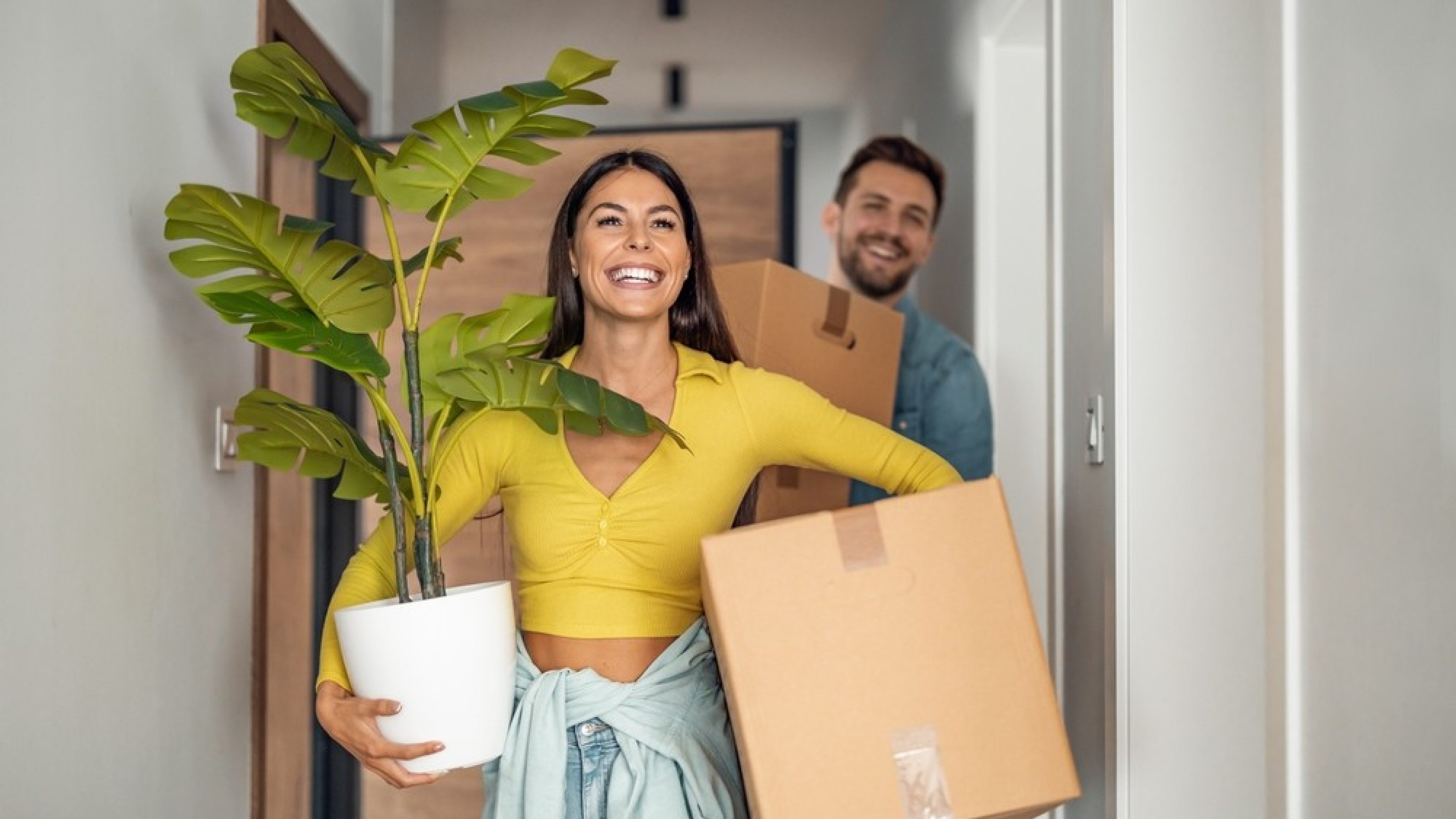 Young couple moving in new home.Couple is having fun with cardboard boxes in new house at moving day.